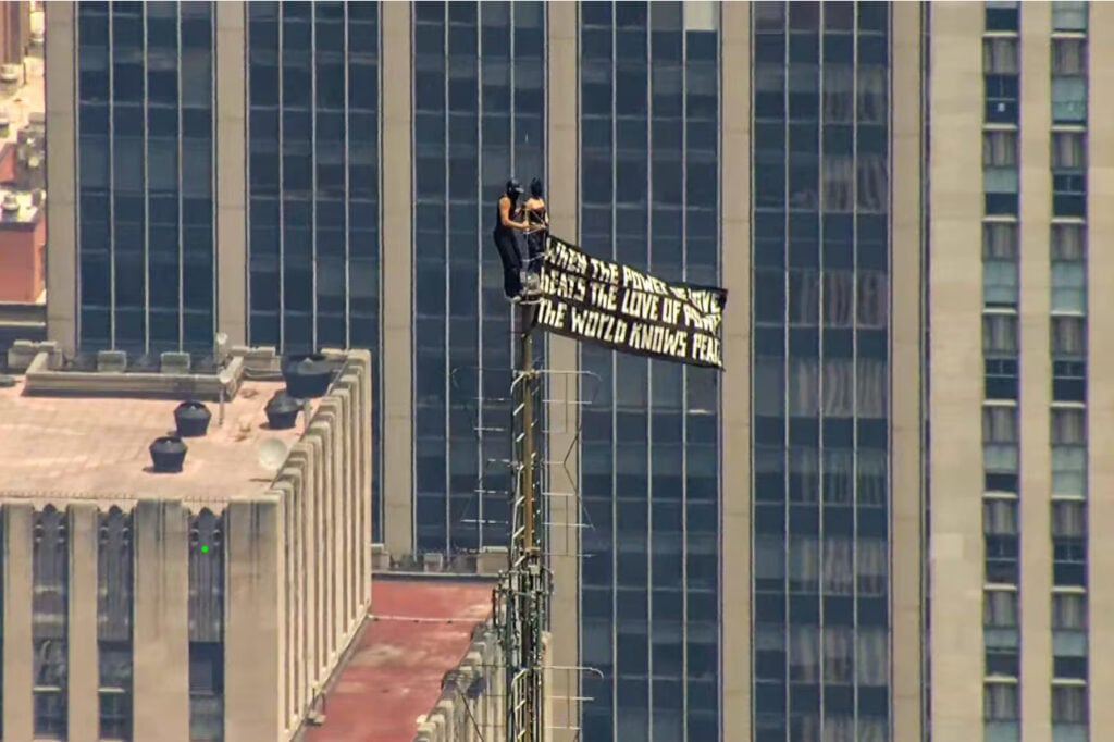 Two People Scale Empire State Building And Unfurl Peace Banner From The Top